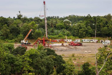 Bunyu Adası-Kuzey Borneo Nisan 1,2025 Endonezya, petrol ve gaz sondaj platformunda dramatik bulutlu tatlı sondajı. Kara petrol sondajı mavi gökyüzü.