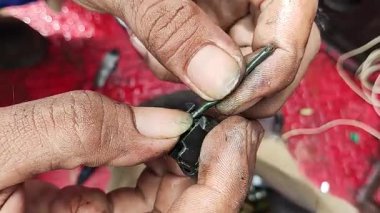 Hasarlı kablo prizini incelemek için elektrikçinin elini kapat.