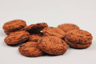 Ölümün izole edilmiş kesme yolu koyu çikolata parçalı kurabiyeler. Yakın plan lezzetli organik fırının beyaz arka planında yığın ve kırıntılar..