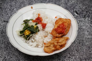 Beyaz seramik tabakta tipik Endonezya ev yapımı mezeler tempeh, sebze ve mısır..