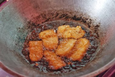 Tempe unu fırının üstünde sıcak yağda kızartılıyor, Endonezya geleneksel yemek pişirme süreci, çıtır çıtır ve altın dokular..