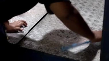 Balkpapan-Endonezya Mayıs 09.2025 İşçiler atölyede alüminyum karşılama zeminini fırçalıyorlar.