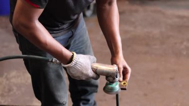 Balkpapan-Endonezya Mayıs 09.2025 İnşaatçı bir üçkağıtçıyla çalışıyor. Tel temizleme fırçası. Pas ve betondan yapılmış temizleme metali. İşçi, metalden pas temizlemek için öğütücü kullanıyor.
