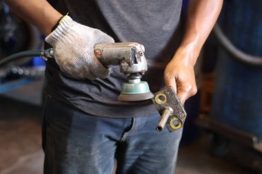 Balkpapan-Endonezya Mayıs 09.2025 İnşaatçı bir üçkağıtçıyla çalışıyor. Tel temizleme fırçası. Pas ve betondan yapılmış temizleme metali. İşçi, metalden pas temizlemek için öğütücü kullanıyor.