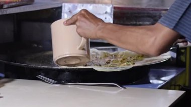 Bir Martabak Telur yapma ya da pişirme süreci. Tavada sıcak yağ ile kızartılan aperatifler yumurta, et, sebze ve baharatla dolu undan yapılır..