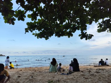 Balikpapan-Endonezya 11 Mayıs 2025 plaj insanları mutlu bir çift Balikpapan plajı ünlü turizm beldesinde gün batımının tadını çıkarıyor..