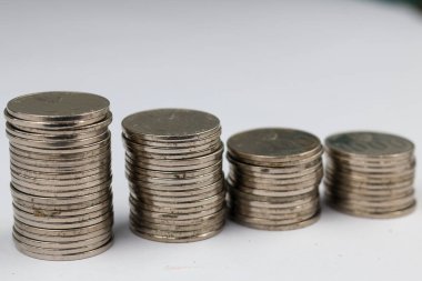 Üstüste yığılmış gümüş paralar beyaz arkaplanda izole edilmiş farklı pozisyonlardadırlar..