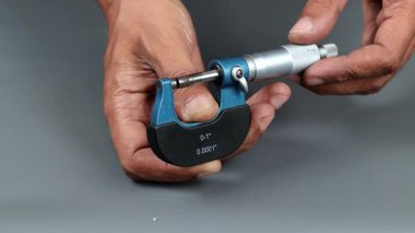 El ele tutuşan analog mikrometre veya diff mikrometre, mikrometre dışındaki ayarlama gri arkaplan üzerinde.