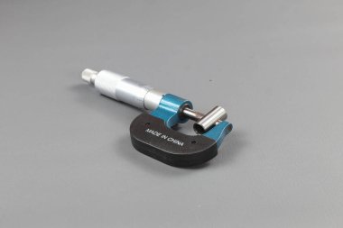 Analog mikrometre ya da diff mikrometre kalite kontrol tüpü gri masanın üzerinde. Vida ölçer kalibreleri analogu kullan. kalite kontrol kavramı.