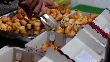 Satıcı pisang keju, Pisang goreng tepung keju, peynirli muz ve çikolatalı makarna servis edip hazırlıyor. Endonezya sokak yemekleri.
