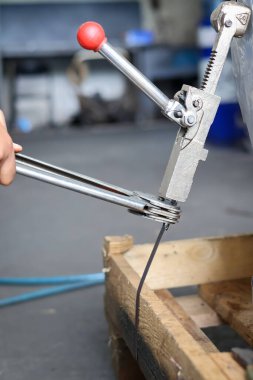 Paketlerin elle bağlanması, metal şeritleri germek için bir cihaz kullanarak elinizi kapatın. Kutuları ve paletleri bağlamak için araç.