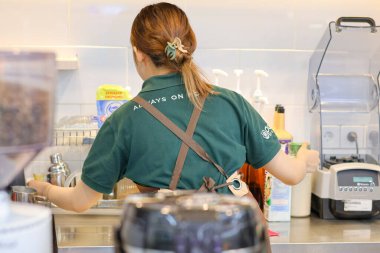 Balikpapan-Endonezya 22 Mayıs 2025 Güzel Asyalı bayan barista kahve makinesiyle Endonezya 'nın İndomaret bölgesinde çalışıyor..