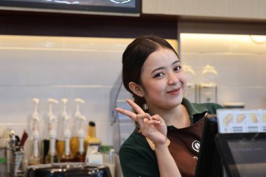 Balikpapan-Endonezya 22 Mayıs 2025 Güzel Asyalı bayan barista kahve makinesiyle Endonezya 'nın İndomaret bölgesinde çalışıyor..
