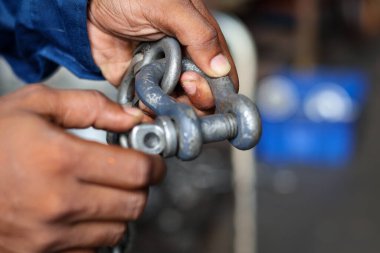 Teknisyenlerin el ele tutuşmalarını kapatın ve zincirin prangalarını sıkın.