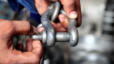 Teknisyenlerin el ele tutuşmalarını kapatın ve zincirin prangalarını sıkın.