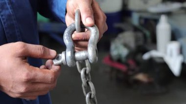 Teknisyenlerin el ele tutuşmalarını kapatın ve zincirin prangalarını sıkın.