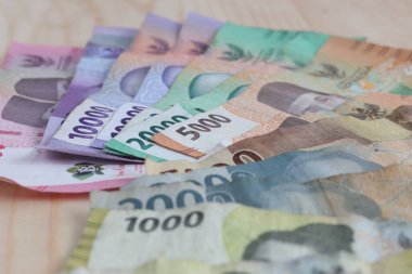 Endonezya rupiah yığını. Ahşap masa üzerinde çeşitli mezhepler var..