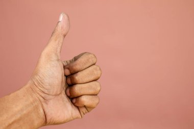 Onay olarak baş parmağını kaldıran kişi, güzel, tamam jest. Beyaz arka planda baş parmak hareketi gösteren bir adamın eli.