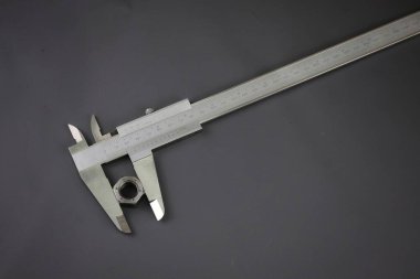 Vernier kalibre dış çapı gri arka planda vida fındık. Dış ve iç boyutların yüksek hassasiyetli ölçümleri için tasarlanmış evrensel araç. 