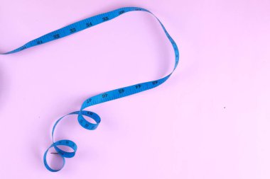 Mavi mezura pembe arka planda izole edilmiş. Kilo verme kavramı için diyet.