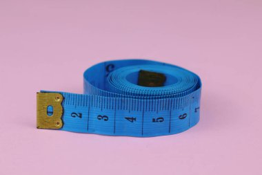 Mavi mezura pembe arka planda izole edilmiş. Kilo verme kavramı için diyet.