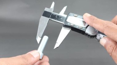 Siyah zemin üzerinde dijital vernier kalibre kullanarak el ölçümü büyüsü sürgüsü. Dış ve iç boyutların yüksek hassasiyetli ölçümleri için evrensel araç. Ölçüm aracı.