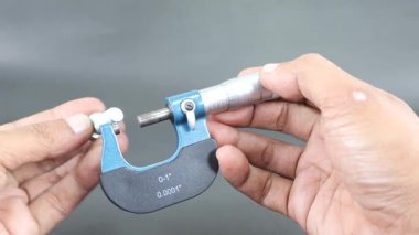 Siyah arka planda vida mikrometre kullanarak el ölçümü büyüsü sürgüsü. Dış ve iç boyutların yüksek hassasiyetli ölçümleri için evrensel araç. Ölçüm aracı.