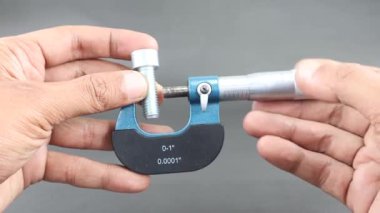 Siyah arka planda vida mikrometre kullanarak el ölçümü büyüsü sürgüsü. Dış ve iç boyutların yüksek hassasiyetli ölçümleri için evrensel araç. Ölçüm aracı.