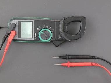 Gri arkaplanda sonda testi izole edilmiş üst görünüm dijital klemp metresi.