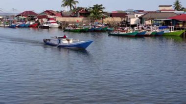 Öğleden sonra Manggar balıkçı köyünde sakin bir atmosferi olan geleneksel balıkçı tekneleri sıraya dizilmişti.