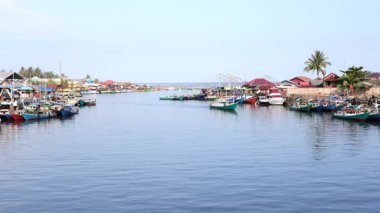 Manggar Nehri 'ndeki ahşap tekneleri kullanarak öğleden sonra balıkçı köyünde demirlemiş teknelerle geleneksel balıkçılık faaliyetleri.