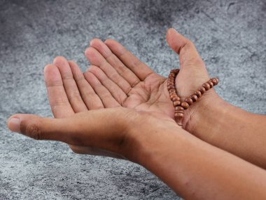 Tasbih 'i tutan eller ve hareketler izole edilmiş arka planda dua ediyor. İslam kavramı.