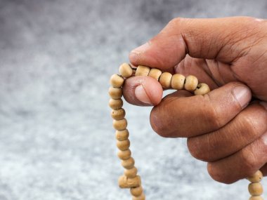 Arkaplanı bulanık olan dua boncuklarıyla dhikr okuyan elleri kapatın. Dzikir el