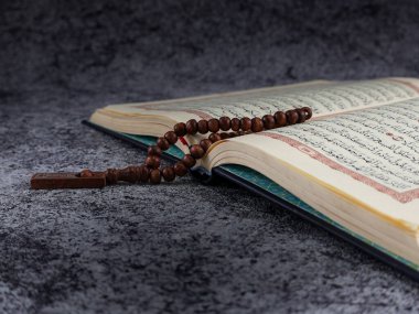 Balikpapan-Endonezya 5 Ağustos 2025 Kutsal Kur 'an tasbih ya da tespih taneleri sayfası açıldı. İzole edilmiş arkaplan.