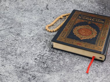 Balikpapan-Endonezya 5 Ağustos 2025 Kutsal Kur 'an' ın Arapça el yazısı ve arkaplanda tasbih ya da tespih anlamına gelen tespih. 