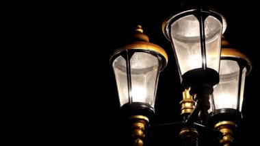 Eskimiş sokak lambaları karanlık gece arkaplanlı elektrik direklerinde.