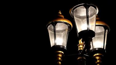 Eskimiş sokak lambaları karanlık gece arkaplanlı elektrik direklerinde.