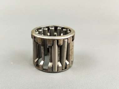 Gri bir yüzeyde bir iğne rulosunun hasar görmesi görülür. Fotoğraf endüstriyel kısmın mekanik hassasiyetini ve metalik dokusunu vurguluyor..