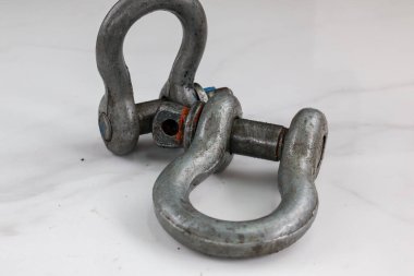 İki galvanize çelik pranga tek bir iğneyle bağlanmış, endüstriyel ve hileli temalar için mükemmel..