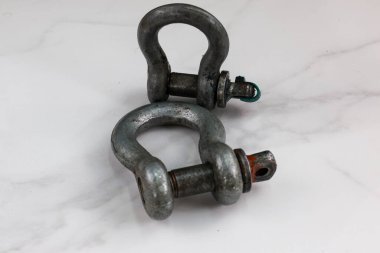 İki galvanize çelik pranga tek bir iğneyle bağlanmış, endüstriyel ve hileli temalar için mükemmel..