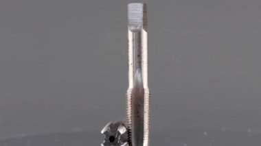 İç iplikleri kesmek için çelik muslukları kapatın. Karanlık bir arka planda izole edilmiş.