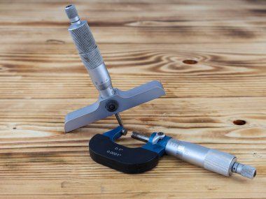 Derinlik mikrometre ve ahşap yüzeydeki harici mikrometre de dahil olmak üzere hassas ölçüm araçlarının kapsamlı bir görüntüsü.