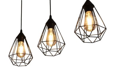 Tavandan sarkan Edison ampulleriyle üç şık geometrik kolye ışığı. Temiz beyaz bir arkaplanda izole edilmiş bu görüntü modern ve endüstriyel ışık için mükemmel.