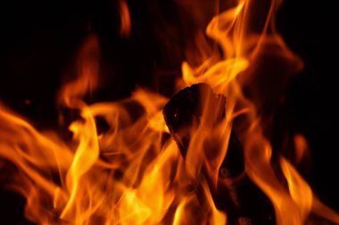 Alevlerle yanan odunlar ve yatay ve dikey yönlerde közler.