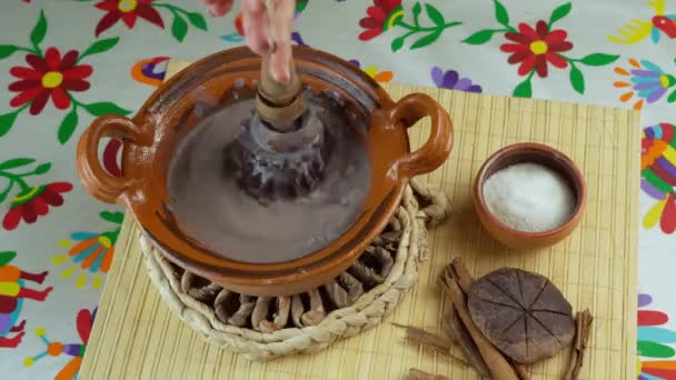 メキシコのチョコレートドリンクは 木製のウィスクを使用して粘土鍋で メキシコのテーブルクロス付きのテーブルで ココア シナモンなどの伝統的な食材 — ストック動画