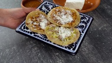 Meksikalı eş bir tabak talavera ve chalupa koyar.