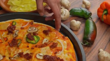 Latin el bir dilim Meksika pizzası alıyor. Manchego peyniri ile hazırlanmış.