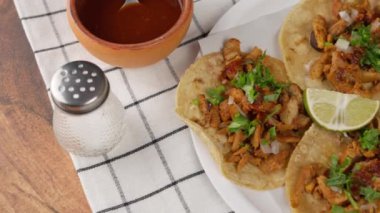 Tacos al pastor, ahşap bir masada Meksika yemeği ve beyaz kumaş arka planda seyahat çekimi.