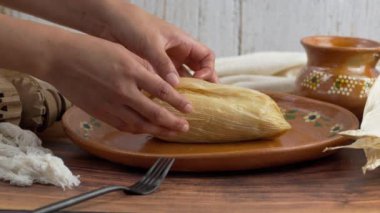 Meksikalı kadın biber şeritli bir tamal açıyor, Meksika yemeği Tamal de rajas