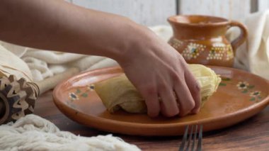 Meksikalı kadın yeşil soslu bir tamal açıyor, Meksika yemeği Tamal de verde